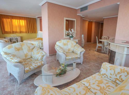 a hotel room with chairs and a living room with a fireplace at KAKTUS Hotel Kaktus Albir in Albir