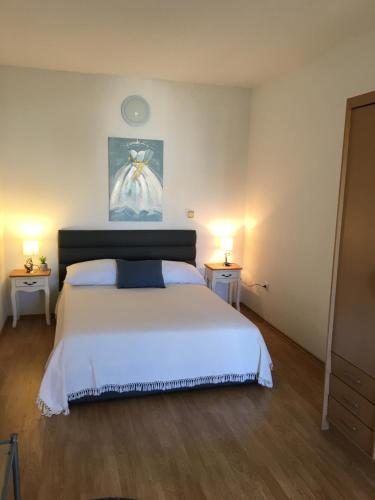 a bedroom with a large white bed and two tables at Amelia Apartment in Vodice