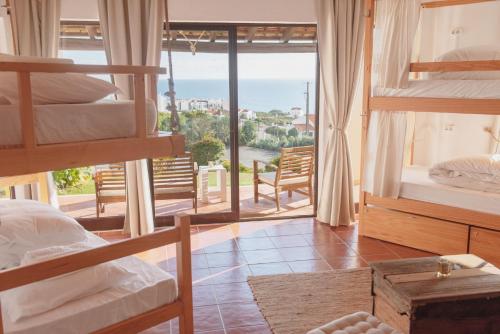 a bedroom with bunk beds and a view of the ocean at Surf Vilas by Laneez Ericeira in Ericeira