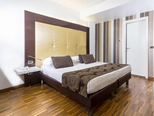 a bedroom with a large bed with a large headboard at Hotel La Bussola in Milazzo