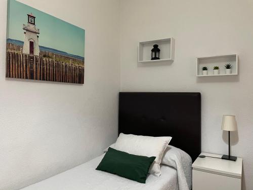 1 dormitorio con 1 cama y una foto en la pared en Apartamento Ciudad Jardín con PARKING, en Córdoba