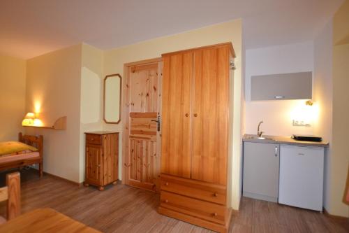 a room with a kitchen and a wooden door at Dom Gościnny Przystań in Międzywodzie