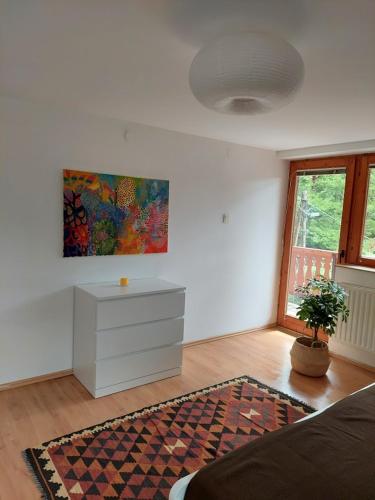 a living room with a dresser and a painting on the wall at Erdőszéli Vendégház Zebegény in Zebegény