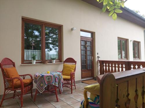 eine Terrasse mit Stühlen, einem Tisch und Stühlen in der Unterkunft Erdőszéli Vendégház Zebegény in Zebegény