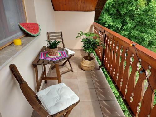 a balcony with two chairs and a table on a porch at Erdőszéli Vendégház Zebegény in Zebegény