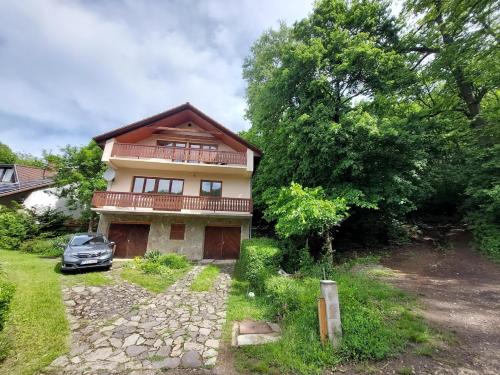 a house with a car parked in front of it at Erdőszéli Vendégház Zebegény in Zebegény