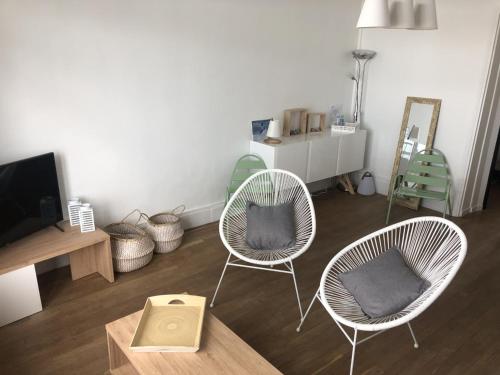 een woonkamer met twee stoelen en een tafel bij Villa les Fleurs Appartement en front de mer in Mers-les-Bains