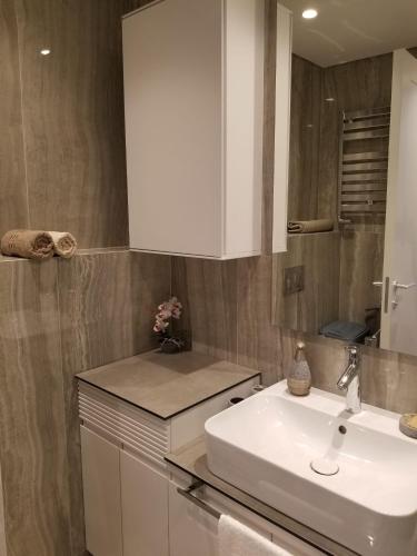 a bathroom with a white sink and a mirror at Azura Residence - new luxury apartment in Belgrade