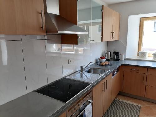 kuchnia ze zlewem i kuchenką w obiekcie Living Apart Haslwanter Ferienwohnung w mieście Haiming