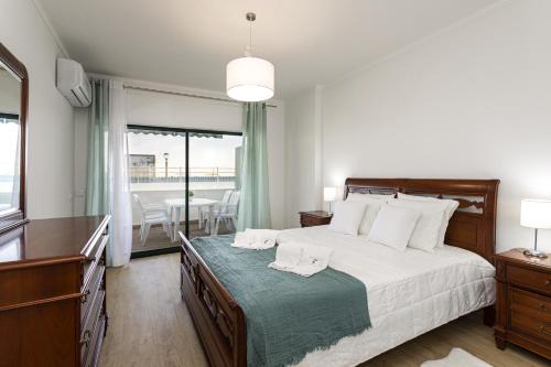 a bedroom with a bed and a table with chairs at Miral 2 - Beach front apartment with pool in Quarteira