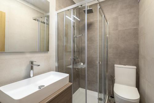 a bathroom with a toilet and a sink and a shower at Miral 2 - Beach front apartment with pool in Quarteira