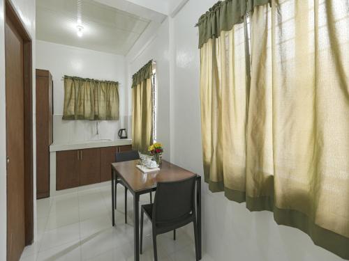 a room with a table and chairs and a kitchen at OYO 736 Jade Apartelle in Malitlit