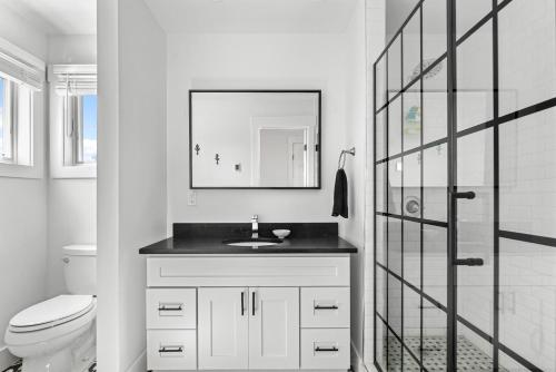 a bathroom with a sink and a toilet and a mirror at Poolside Chic by the Sea in Ocean Bay Park