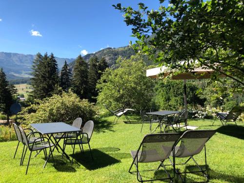 a group of tables and chairs in the grass at Au Rascard in Brusson