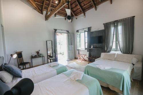 a living room with two beds and a couch at Estancia La Paz Hotel in Ascochinga