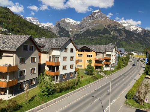 a street in a town with mountains in the background at Spirit Apartments - Neben dem Titlis - Parkplatz in Engelberg