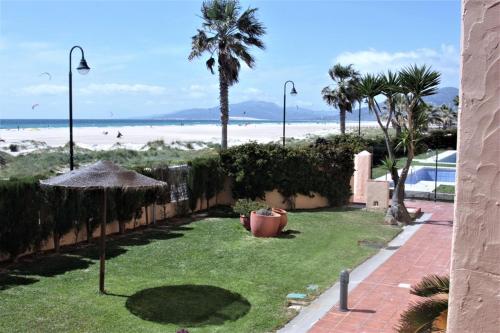 einen Hof mit Sonnenschirm und Strand in der Unterkunft Playa de Los Lances in Tarifa