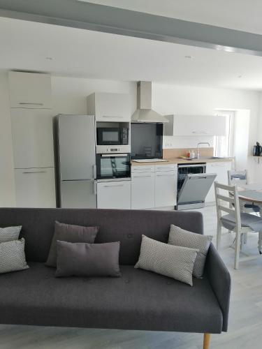 un salon avec un canapé et une cuisine dans l'établissement Maison de campagne 