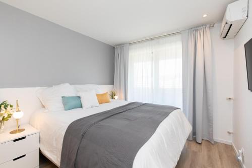 une chambre blanche avec un grand lit et une fenêtre dans l'établissement HeavnStay Suite Cannes Centre I, à Cannes
