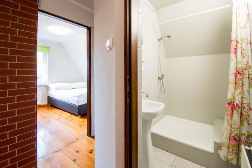 a bathroom with a shower and a sink and a bed at Dom z widokiem na jezioro Tajty - Wilkasy Zalesie in Giżycko