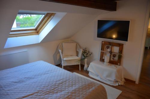 a bedroom with a bed and a chair and a tv at Grimming View in Niederöblarn
