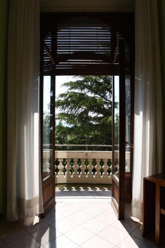 an open door to a balcony with a tree at Villa San Giuseppe in Brescia