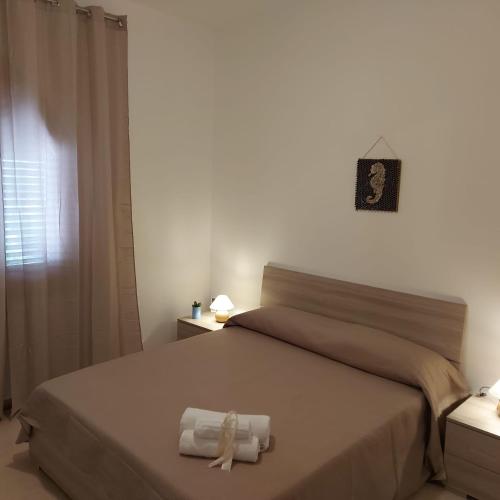 a bedroom with a bed with rolled towels on it at Villa Torre Magaggiari in Cinisi