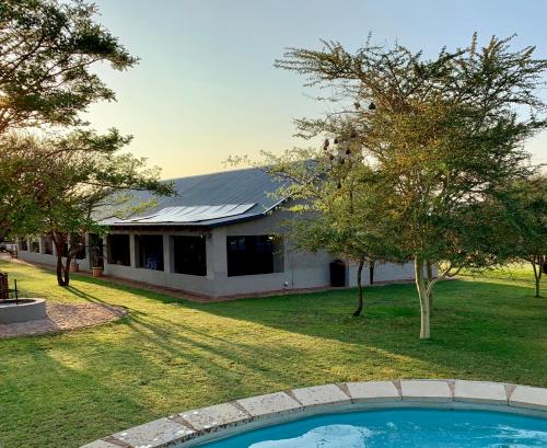 a house with a swimming pool in the yard at Tula Baba Game Lodge in Brits