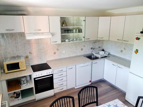 una cocina blanca con armarios y electrodomésticos blancos en APARTMA NANA STRUNJAN, en Portorož