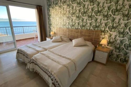 Schlafzimmer mit einem großen Bett und Meerblick in der Unterkunft Amazing frontline sea views Studio apartment Castillo Del Vigia Torremolinos in Torremolinos