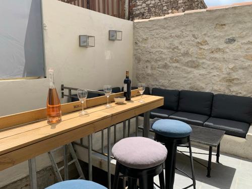 - un bar avec deux tabourets et une table avec des verres à vin dans l'établissement Sur la Terrasse, à Sigean