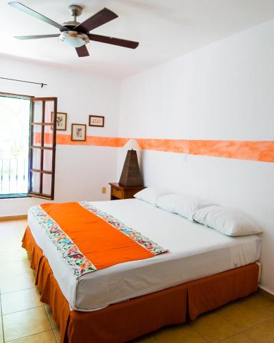 a bedroom with a bed and a ceiling fan at Hotel Casa de las Flores in Playa del Carmen