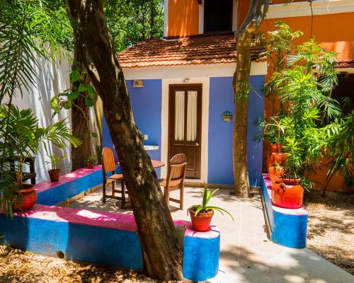 a house with blue and red walls and trees at Hotel Casa de las Flores in Playa del Carmen