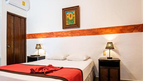 a bedroom with a bed with a red blanket at Hotel Casa de las Flores in Playa del Carmen