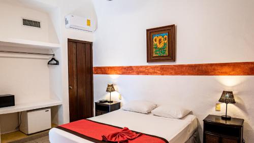a hotel room with a bed with a red blanket at Hotel Casa de las Flores in Playa del Carmen