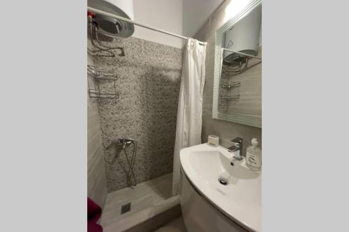 een badkamer met een wastafel en een douche bij RUSTIC DIAMOND new apartment near the beach in Porto Rafti
