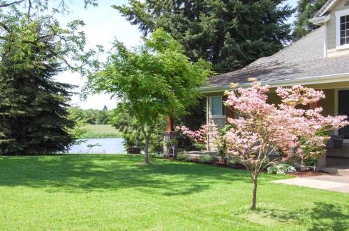 a house with a flowering tree in the yard at McMinnville Wine Country Home with Hot Tub and Deck in McMinnville