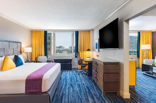 a hotel room with a bed and a flat screen tv at E Central Hotel Downtown Los Angeles in Los Angeles