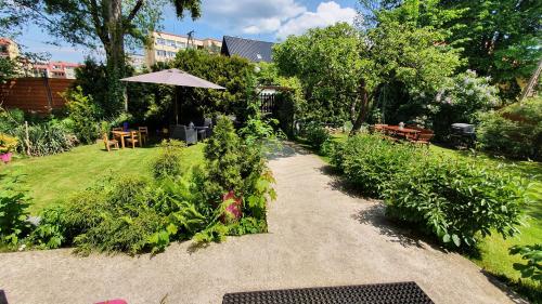 a garden with a table and an umbrella and plants at Willa Nad Potokiem in Kudowa-Zdrój