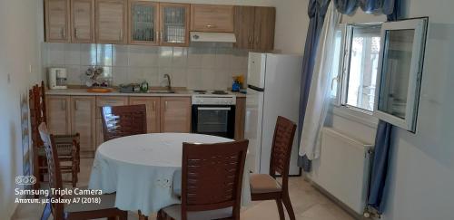 uma cozinha com uma mesa branca e um frigorífico branco em Achille's apartment em Plataria