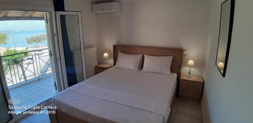 sypialnia z łóżkiem i balkonem w obiekcie Achille's apartment w mieście Plataria