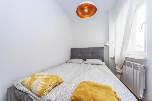 a bedroom with a bed with a yellow blanket on it at Hello Apartments Dworska LIGHT in Gdańsk