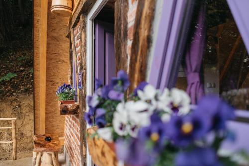 a bunch of purple and white flowers in a window at Etno Village Dolina Sreće in Vitez