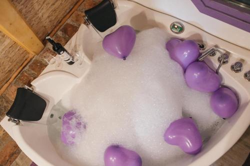 a bathroom sink with purple hearts in it at Etno Village Dolina Sreće in Vitez