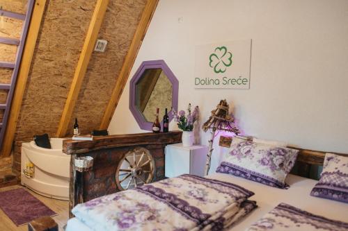 a room with a bed and a mirror and a wheel at Etno Village Dolina Sreće in Vitez