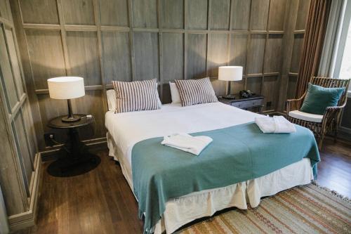 a bedroom with a large bed with two lamps at Estancia La Paz Hotel in Ascochinga