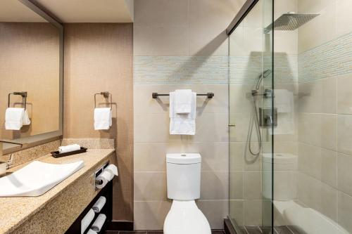 a bathroom with a toilet and a glass shower at E Central Hotel Downtown Los Angeles in Los Angeles