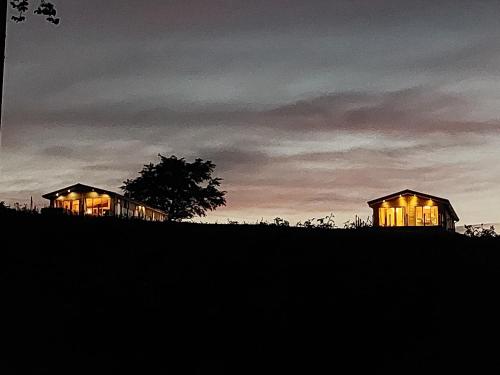 a couple of houses on a hill at night at Luxury family Beechwood lodge with hot tub in Lochwinnoch