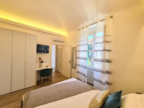 a bedroom with a bed and a desk and a window at SONI APARTMENT in La Spezia