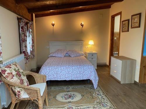 a bedroom with a bed and a chair and a table at Fonte San Pedrín in Cajide